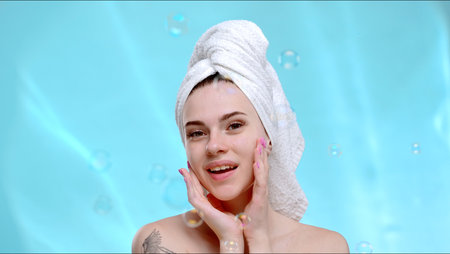 Woman Smiling with Towel Wrapped Hair against Blue Backgroundの写真素材