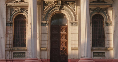 A vintage suitcase left on the steps of a massive door of an antique building with columns. The concept of a journey, waiting, or memories.の写真素材