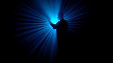 A dark figure of a martial arts master practices his skills, performing various stances in front of a powerful blue light, creating radial rays of illumination.の写真素材