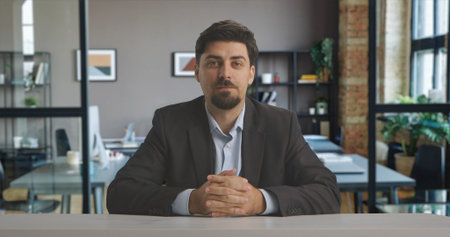 A man in a suit sits confidently in a professional live streaming studio setup, ready to broadcast...