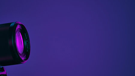 A close up shot of a camera lens illuminated by purple studio lighting, offering a modern and artistic feel.の写真素材
