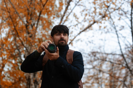 Photographer Capturing Autumn Scene in Parkの写真素材