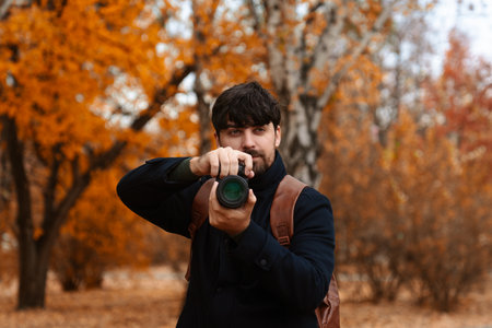Photographer Capturing Autumn Scene in Parkの写真素材