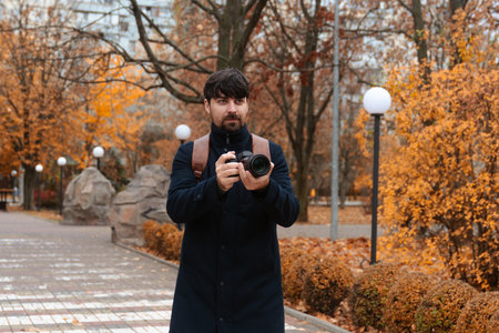 Photographer Capturing Autumn Scene in Parkの写真素材