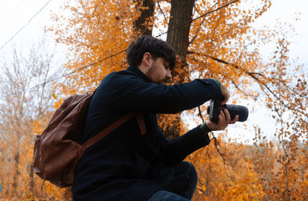 Photographer Capturing Autumn Scene in Parkの写真素材