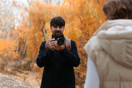 Couple Reviewing Camera Photos in Autumn Parkの写真素材