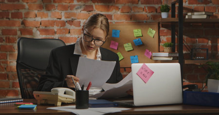 Young Businesswoman in Office with Brick Wall Backgroundの写真素材