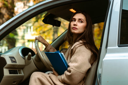 Woman Sitting in Car Holding Blue Folderの写真素材