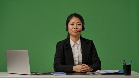 A young Korean businesswoman in a black suit and headset looks at the cameraの写真素材