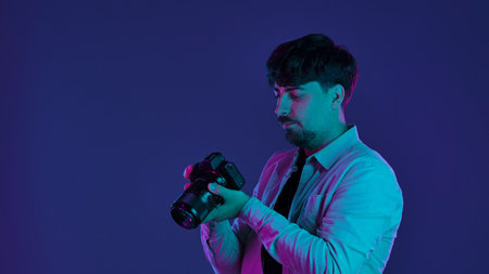Photographer in neon lighting holding a cameraの写真素材