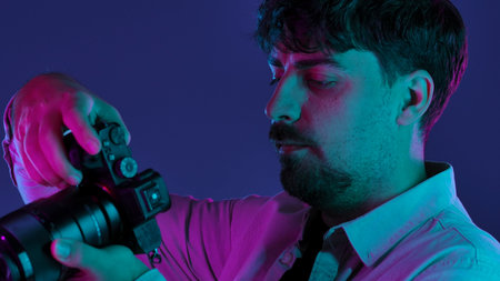 Photographer in neon lighting holding a camera