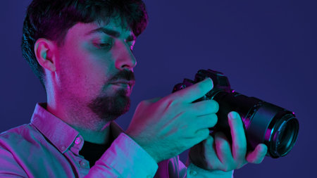 Photographer in neon lighting holding a camera