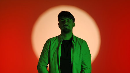 Man in Green Light Against Red and White Circle Background