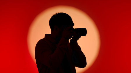 Backstage Silhouette of Photographer Against Red and Orange Background