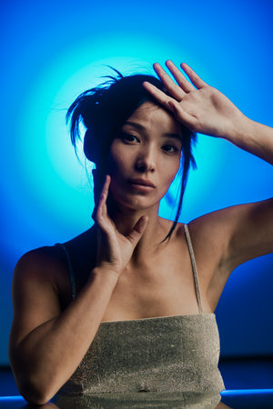 Elegant Woman in Dramatic Blue Light Reflectionの写真素材