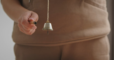 Close up of Hand Holding Small Brass Bellの写真素材