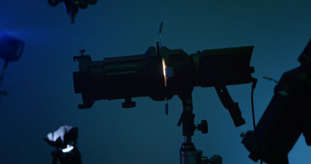 A silhouette of a stage spotlight in a dark environment, showcasing lighting equipment and...