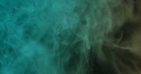 Soft teal smoke gently swirling on a dark backdrop, creating a dreamy atmospheric texture perfect for modern designs, posters, headers, and presentations.の写真素材