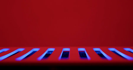 Minimal abstract background with blue glowing ventilation slots on red surface, ideal for futuristic technology designs, headers and banners.の写真素材
