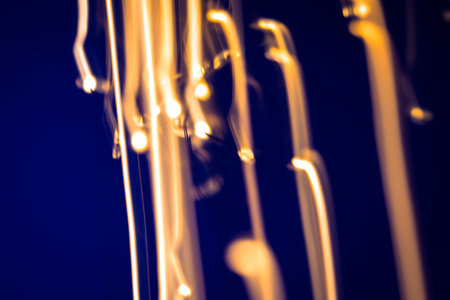 Artistic abstract background featuring soft golden bokeh against a deep blue background, creating a...