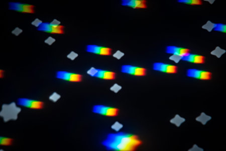 Abstract rainbow gobo projection with bright spectral streaks and soft star bokeh on a dark studio...