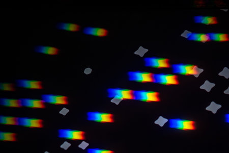 Abstract rainbow gobo projection with bright spectral streaks and soft star bokeh on a dark studio...