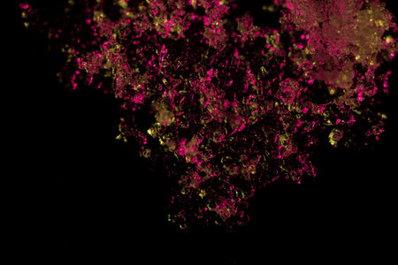 Close up of frosty snowflakes and icy patterns on glass, beautifully illuminated with a vibrant...