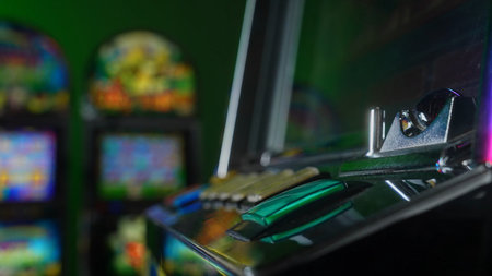 Close up of a green START button on a casino slot machine control panel. Colorful illuminated keys...