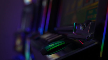 Close up of a green START button on a casino slot machine control panel. Colorful illuminated keys...
