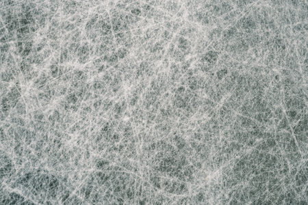 Abstract top view of scratched ice rink surface with skate marks and frozen texture. Cold winter...