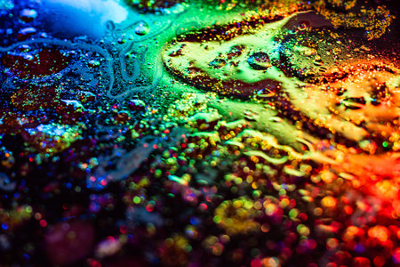 Colorful abstract divorces of oily liquid with neon red, blue and green highlights. Bubbles, stains and shimmering texture create a vivid futuristic background.の写真素材