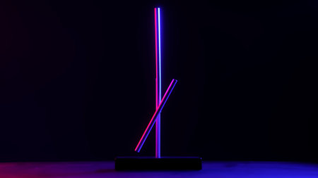 Minimalist magnetic pendulum desk sculpture illuminated with neon blue and pink light on a dark...