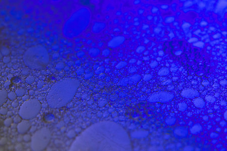 Soft abstract beauty background with delicate oil bubbles floating in clear liquid, illuminated by...