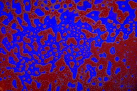 Abstract background of blue and red paint divorces, streaks and particles suspended in liquid....