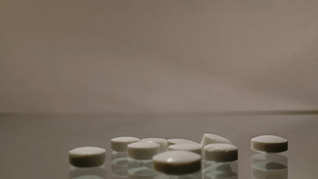 White tablets arranged on a reflective surface against a neutral background with soft studio...