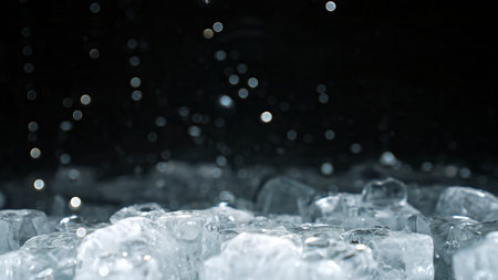 Ice cubes with falling water drops and light bokeh on dark background. Advertising concepts for...