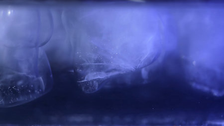 Close up of ice cubes underwater with oxygen bubbles, frost patterns, and soft light reflections....