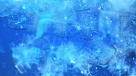 Close up of blue ice cubes underwater with oxygen bubbles, frost patterns, and soft light...