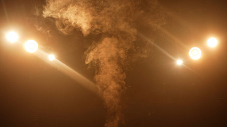 Rising column of stage smoke illuminated by bright spotlights in a dark theatrical space. Concept of...
