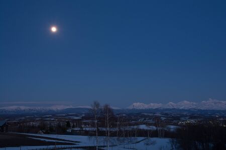Full Moon and Mountain Range in Spring Tokachi,Mountain Rangeの写真素材