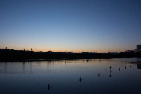 Beautiful dusk sky reflected on the waterの写真素材