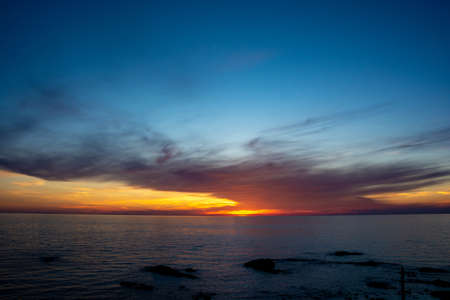 The sea at dusk reflecting the sunの写真素材
