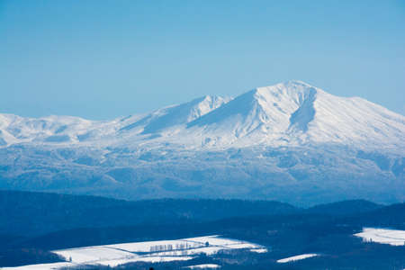 Snowy mountain peak and blue skyの写真素材