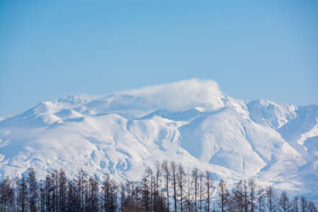 Winter summit with volcanic plume and blue skyの写真素材