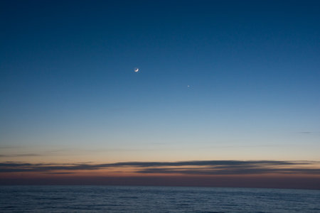 Crescent and Venus in the beautiful sea dusk skyの写真素材