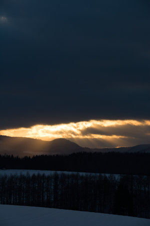 Sunlight shining through the clouds in the winter skyの写真素材