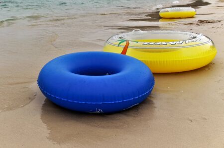 A colorful swim ring is placed on the beach for tourists to swim in the sea.の写真素材