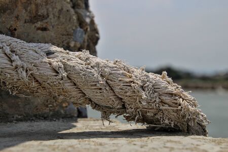 The rope that is tied to the cement post that is exposed to the wind and sunshine every day.の写真素材