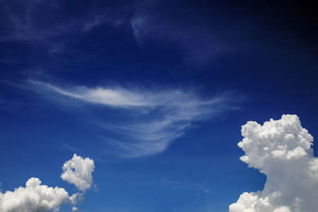 On a clear day the sky is dark blue. Clouds form in various shapes and some are scattered by the wind.の写真素材