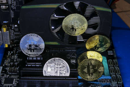 Bitcoin coins that are placed on a VGA card and a computer motherboard. Concept about Cryptocurrency Bitcoin Finance Investments and Stop Mining When Prices Dropの写真素材